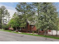 Charming brick home nestled among mature trees offers privacy and curb appeal at 120 Silver Leaf Way, Castle Rock, CO 80108
