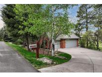 Charming brick home featuring mature trees, a well-manicured lawn and a two car garage at 120 Silver Leaf Way, Castle Rock, CO 80108