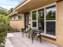 Charming home featuring a cozy front porch with seating, large window, and manicured landscaping at 5995 Estes St, Arvada, CO 80004