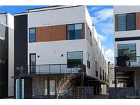 Modern townhome featuring a mix of white and wood paneling, black accents, and a compact front balcony at 1930 Hooker St # 3, Denver, CO 80204