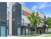 Modern townhome exterior with a blue door, black metal accents, and a small balcony with grilling equipment at 1930 Hooker St # 3, Denver, CO 80204