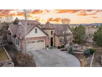 Beautiful two-story brick home with a two-car garage and outdoor firepit at sunset at 10431 Marigold Ct, Highlands Ranch, CO 80126