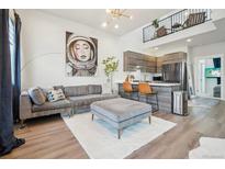 Stylish living room featuring a modern sofa, ottoman, and a striking art piece at 3550 W 63Rd Ave, Denver, CO 80221