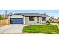 Charming single-story home featuring a well-manicured lawn, a blue two-car garage, and a welcoming front entrance at 2484 E 101St Ct, Thornton, CO 80229