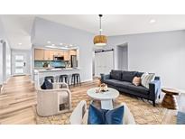 Bright living room showcases an open floor plan with a modern kitchen and stylish furnishings at 2484 E 101St Ct, Thornton, CO 80229