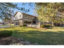 Charming two-story home with lush green lawn, mature trees, and manicured landscaping at 6269 S Coventry E Ln, Littleton, CO 80123