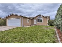 Charming single-story home featuring a well-maintained front yard and attached garage at 664 Stampede Dr, Brighton, CO 80603