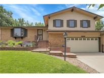 Charming two-story home with a brick exterior, landscaped front yard and well manicured lawn at 11936 E Oregon Cir, Aurora, CO 80012