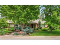 Landscaped front yard with mature trees and well-manicured bushes and stone accents in a beautiful residential area at 3401 E Kentucky Ave, Denver, CO 80209