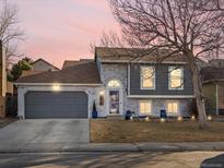 Charming two-story home featuring brick accents, gray siding and a well-maintained front yard at 13490 W 65Th Ave, Arvada, CO 80004