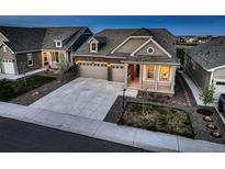 Inviting home featuring a manicured lawn, stone accents, and an attached two car garage at 15788 Valentia St, Thornton, CO 80602