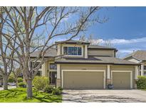 Beautiful home featuring a three-car garage, green lawn, and mature tree shading the property in the daytime at 15976 Quarry Hill Dr, Parker, CO 80134