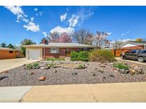 Charming brick home featuring a well-kept yard with rock landscaping and a cozy, inviting entrance at 6105 Benton St, Arvada, CO 80003