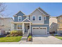 Charming two-story home featuring a covered porch, two-car garage, and well-maintained landscaping at 806 Cabot Dr, Erie, CO 80516