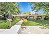 Charming brick home with well-maintained front lawn, mature trees, and inviting curb appeal at 1091 E Pinewood Ave, Centennial, CO 80121