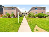 Beautiful two-story brick apartment building with lush green landscaping and a walking path at 2047 S Milwaukee St # 4, Denver, CO 80210
