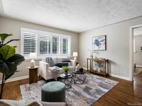 Bright living room features hardwood floors, modern furniture, and white shuttered windows at 2047 S Milwaukee St # 4, Denver, CO 80210