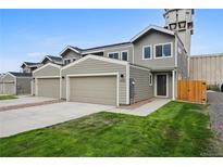 Modern two-story townhome with attached garage and landscaped lawn at 5232 Columbine Ln, Denver, CO 80221