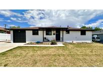 Charming single-story white home featuring a well-manicured lawn, black trim, and inviting curb appeal at 7150 Beach St, Westminster, CO 80030