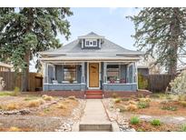 Charming gray home with a landscaped front yard, covered porch, and inviting walkway at 4824 Knox Ct, Denver, CO 80221