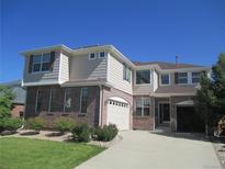 Charming two-story home featuring brick and siding, a well-manicured lawn, and an attached two-car garage at 24763 E Crestridge Pl, Aurora, CO 80016