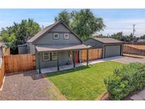 Charming exterior of a home with a red door, green lawn, and detached garage at 2310 S Decatur St, Denver, CO 80219