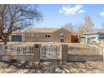 Charming brick ranch-style home with ornamental metal fence and manicured front yard at 1185 Worchester St, Aurora, CO 80011