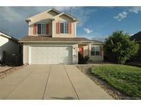 Charming two-story home boasts a spacious driveway and attached garage for easy access and ample parking at 22030 Hill Gail Way, Parker, CO 80138