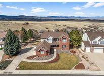 Beautiful two-story home with brick accents and a well-manicured lawn and beautiful mountain view at 3603 Soaring Eagle Ct, Castle Rock, CO 80109