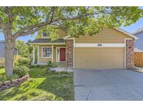 Charming tan two-story home with a red front door, brick accents, and a well-manicured lawn at 12616 Country Meadows Dr, Parker, CO 80134