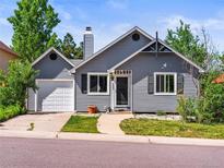 Charming gray home featuring a well-manicured lawn and a driveway leading to an attached one car garage at 4453 S Pagosa Way, Aurora, CO 80015