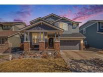 Charming two-story home with covered porch, brick accents, and a well-maintained lawn at 11712 Lewiston St, Commerce City, CO 80022