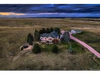 Expansive rural estate featuring a sprawling home with lush landscaping and a separate outbuilding at 3487 Willownook Ranch Trl, Elizabeth, CO 80107