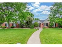 Charming brick home with a lush green lawn, mature trees, and inviting walkway at 3 Glenview Dr, Littleton, CO 80123