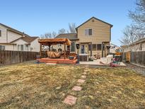 A spacious backyard featuring a deck with a pergola and patio with hot tub at 11395 E 116Th Dr, Commerce City, CO 80640