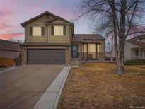 Charming two-story home featuring stone accents, a two-car garage, and manicured landscaping at 11395 E 116Th Dr, Commerce City, CO 80640