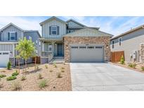 Charming two-story home with a stone facade, gray siding, and a welcoming front porch and a well manicured yard at 1889 Water Birch Way, Castle Rock, CO 80108