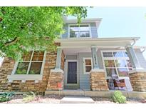 Charming home with stone accents, a welcoming porch, and well-maintained landscaping at 14214 Lakeview Ln, Broomfield, CO 80023
