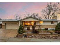 Charming single-story home with brick accents and landscaped front yard against a colorful sunset sky at 8925 W 78Th Ave, Arvada, CO 80005