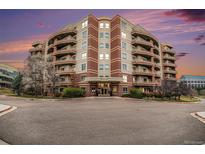Elegant condo building featuring multiple balconies and a brick and beige facade at 4875 S Monaco St # 105, Denver, CO 80237