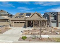 Charming single-Gathering home with a two-car garage, a covered porch, desert landscaping and solar panels at 8099 Arapahoe Peak St, Littleton, CO 80125