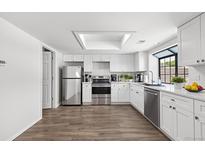 Bright kitchen with stainless steel appliances, white cabinets, and a skylight at 12662 E Warren Dr # F, Aurora, CO 80014