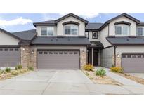 Inviting exterior of townhome with a two-car garage and stone accents at 1849 S Helena St, Aurora, CO 80017