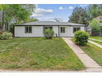 Charming single-story home with white siding, black trim, and a well-manicured green lawn at 1032 Geneva, Aurora, CO 80010