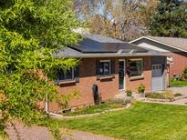 Charming brick home with solar panels, lush lawn, and well-maintained landscaping at 6314 Brooks Dr, Arvada, CO 80004
