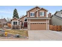 Charming two-story home featuring a brick-accented facade, attached garage, and a well-maintained front yard at 1246 E Phillips Pl, Littleton, CO 80122