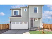 Charming two-story home featuring a spacious garage, well-manicured lawn, and classic architectural details at 17942 E 94Th Pl, Commerce City, CO 80022