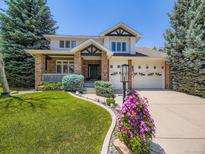 Charming two-story home with brick accents, manicured lawn and beautiful landscaping at 7053 S Shawnee St, Aurora, CO 80016