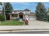 Charming two-story home with brick accents, manicured lawn, and well-maintained landscaping at 7053 S Shawnee St, Aurora, CO 80016