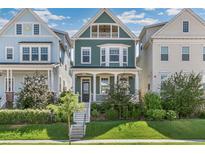 Charming two-story home featuring a covered front porch, well-manicured lawn, and attractive architectural details at 5880 Beeler Ct, Denver, CO 80238